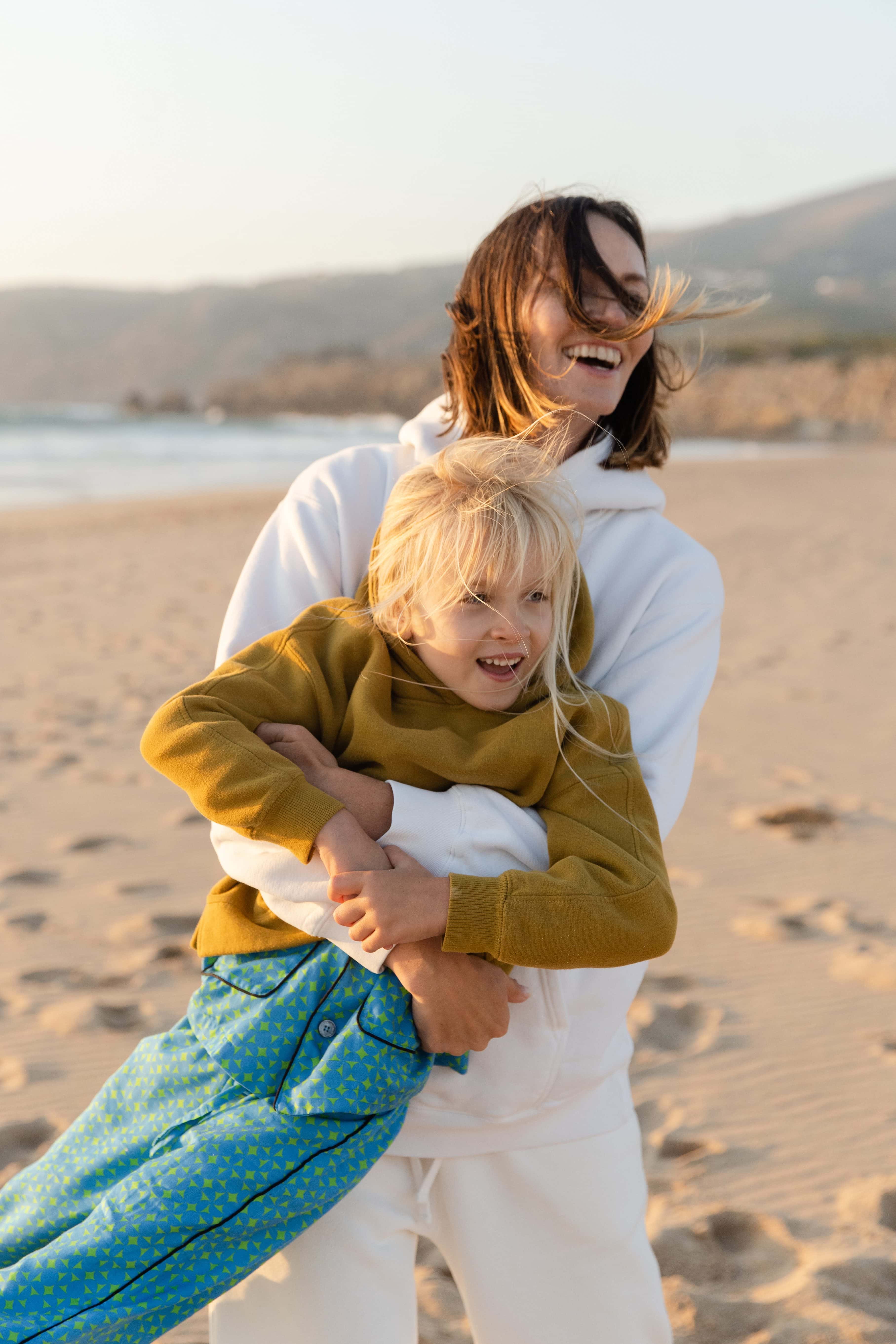 Mother lifting her son on the beach