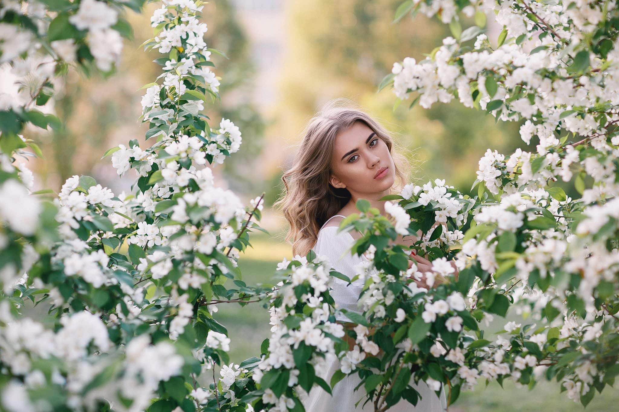 Woman among white blossoms