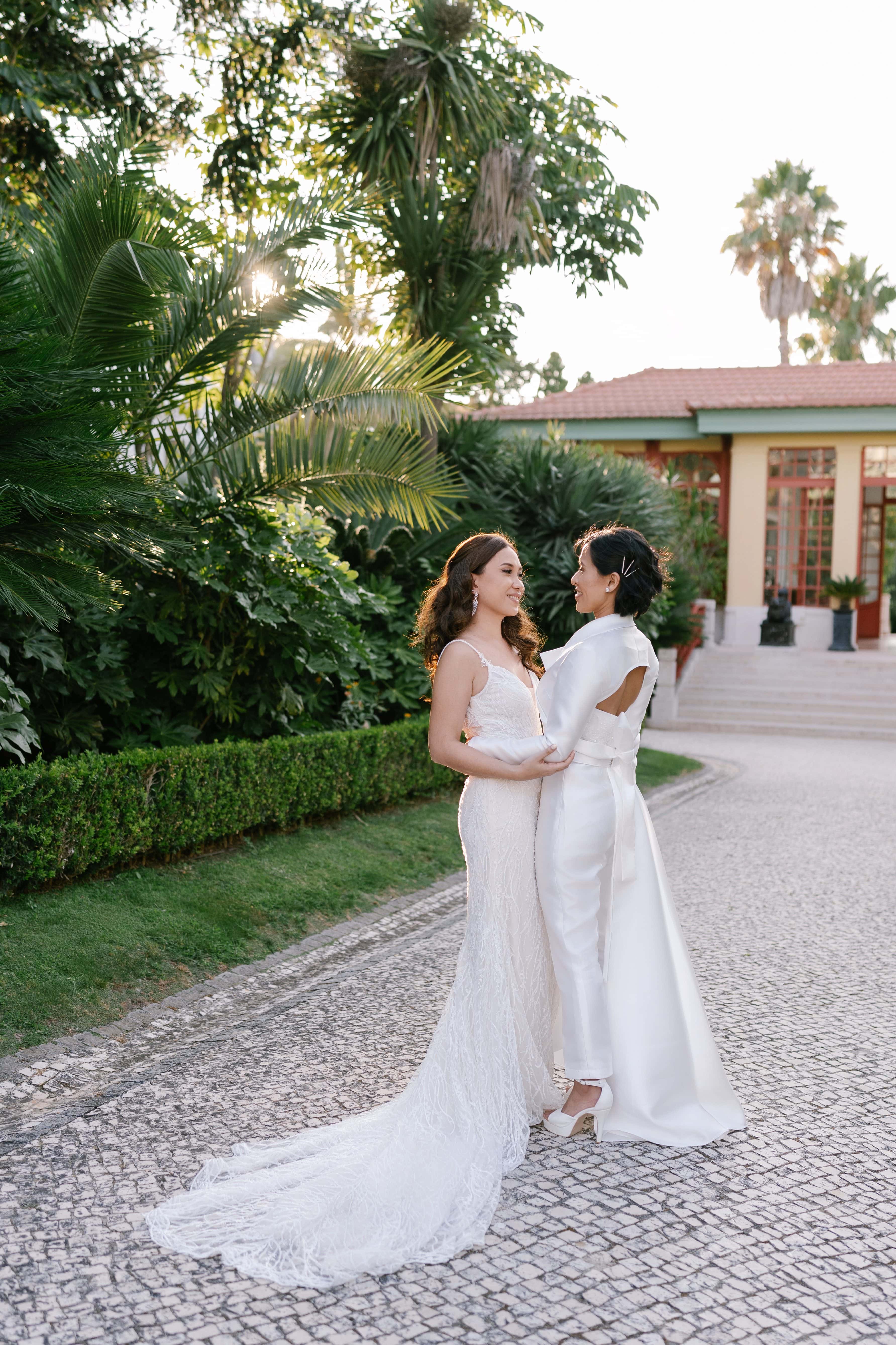 Two brides embracing in the gardens of Pestana Palace Lisbon at golden hour Two brides embracing in the gardens of Pestana Palace Lisbon at golden hour