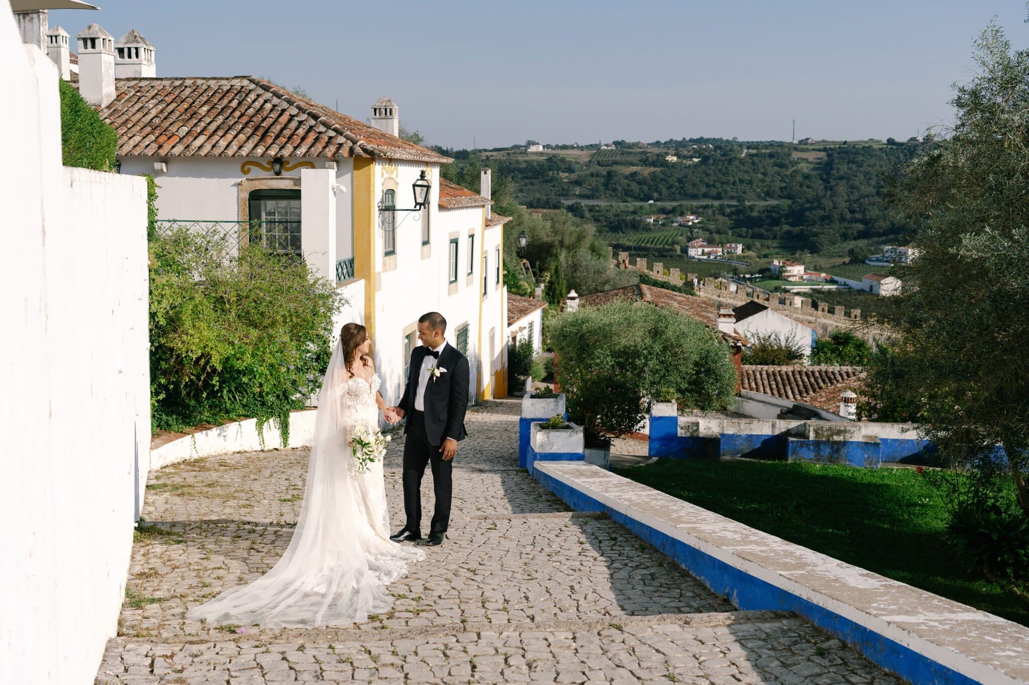 Bride and groom on a cobbled street in Óbidos, Portugal