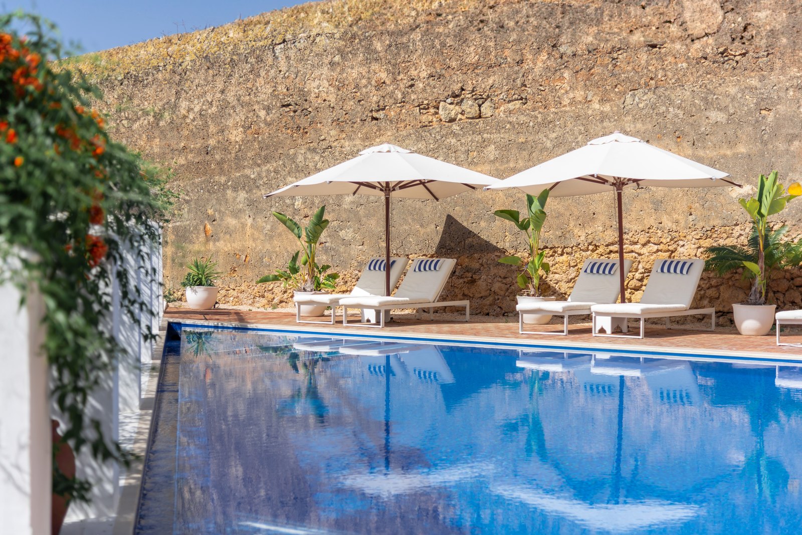 Pool beneath the old town walls of Lagos with white parasols, Casa Mãe Pool beneath the old town walls of Lagos with white parasols, Casa Mãe