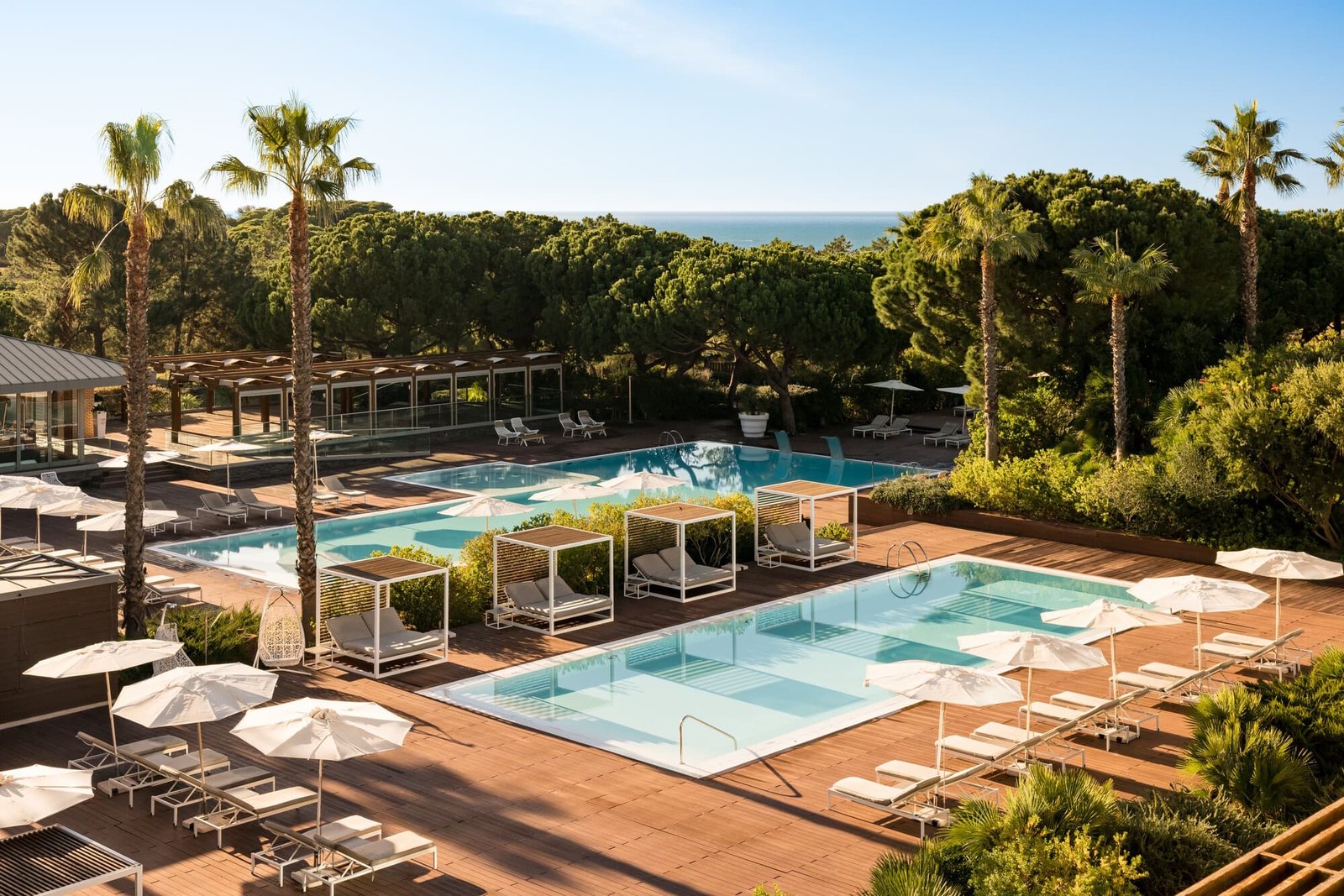 Pools with cabanas and palms among the pine forest, the sea on the horizon, EPIC SANA Algarve, Albufeira Pools with cabanas and palms among the pine forest, the sea on the horizon, EPIC SANA Algarve, Albufeira