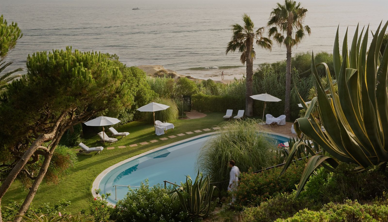 Garden pool among palms and agaves above the sea, Vila Joya, Praia da Galé Garden pool among palms and agaves above the sea, Vila Joya, Praia da Galé