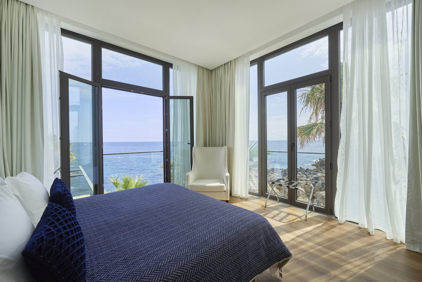 Bedroom with floor-to-ceiling windows onto the sea, Farol Hotel, Cascais Bedroom with floor-to-ceiling windows onto the sea, Farol Hotel, Cascais