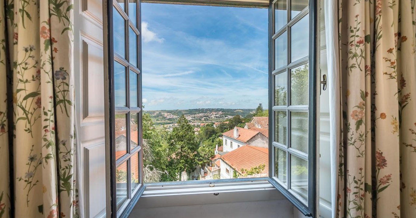 Tall windows open onto the rooftops and the green hills of Sintra, Lawrence's Hotel Tall windows open onto the rooftops and the green hills of Sintra, Lawrence's Hotel