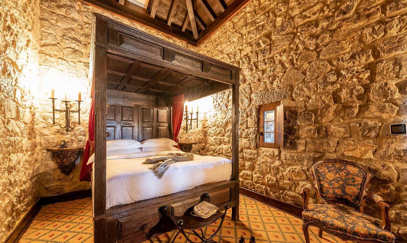 Stone-walled room with a carved four-poster bed, Pousada Castelo de Óbidos Stone-walled room with a carved four-poster bed, Pousada Castelo de Óbidos