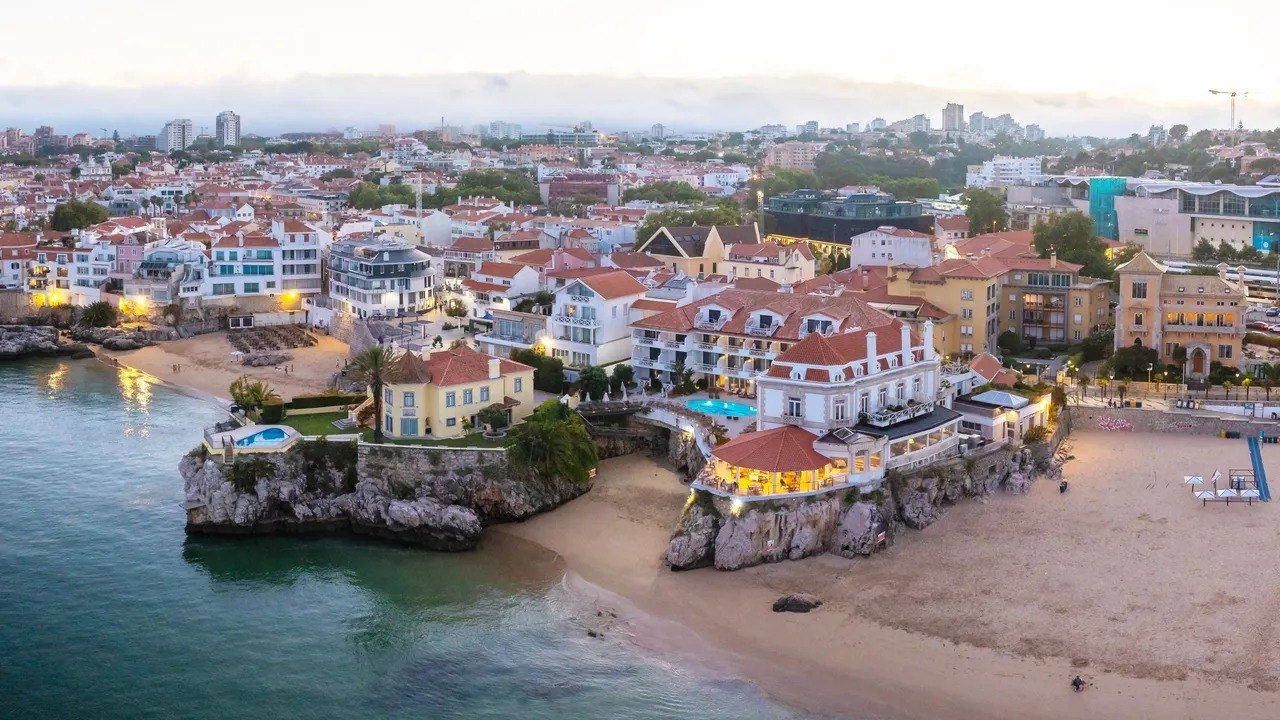 The Albatroz on its rocky headland above the beach and the bay, Cascais The Albatroz on its rocky headland above the beach and the bay, Cascais