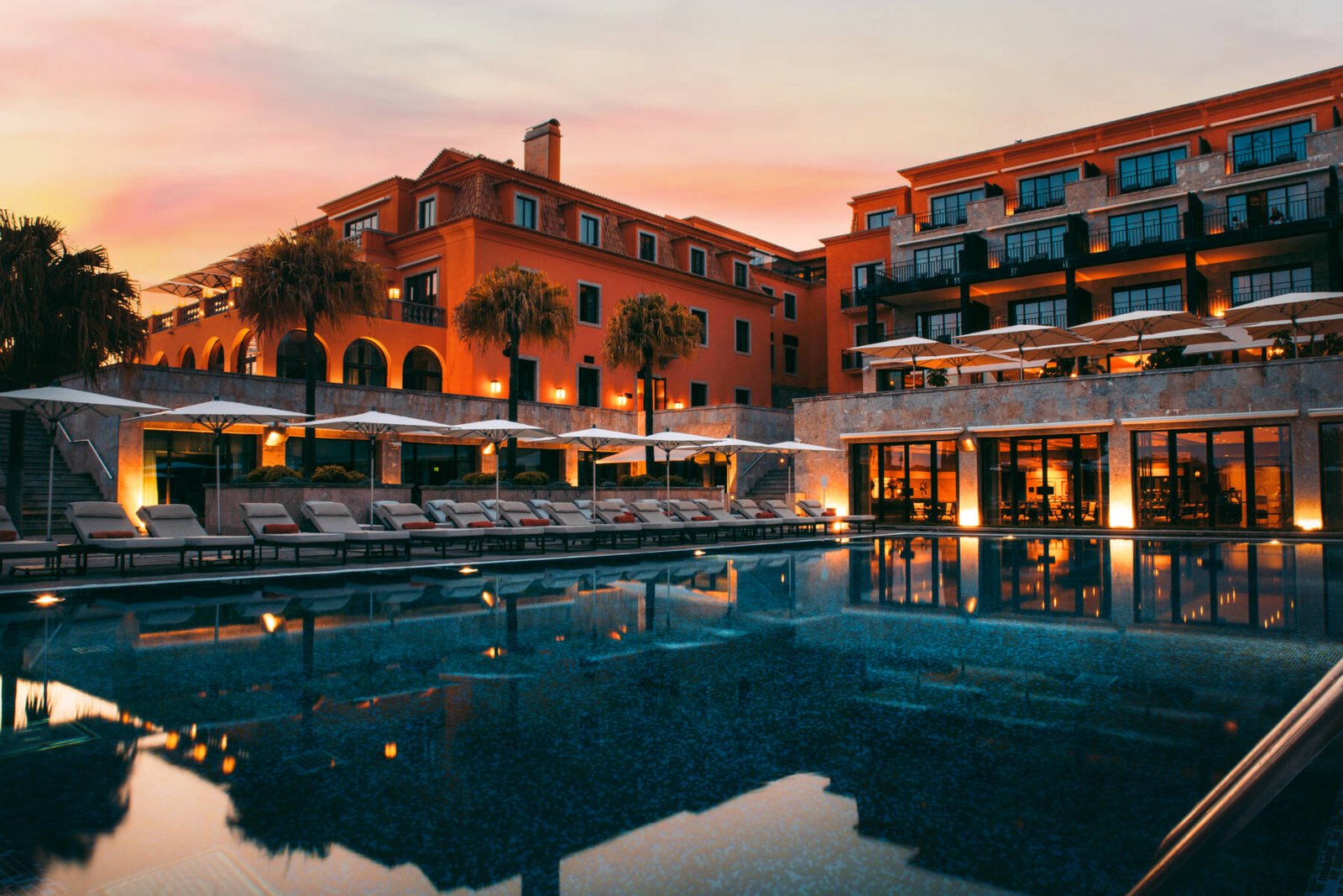 Terracotta buildings and the pool at sunset, Grande Real Villa Itália, Cascais Terracotta buildings and the pool at sunset, Grande Real Villa Itália, Cascais