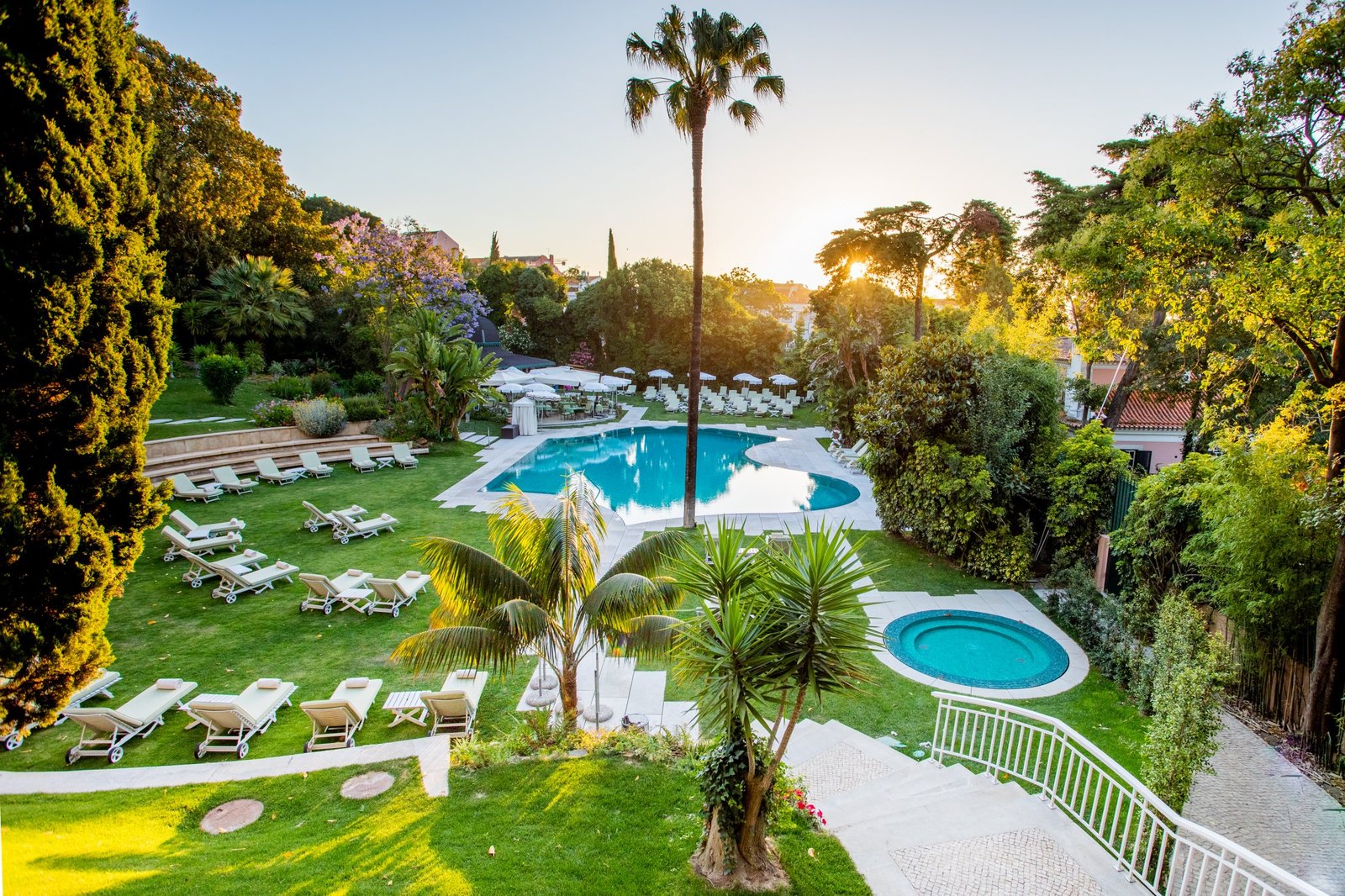 Garden with palm trees and a pool at golden hour, Olissippo Lapa Palace, Lisbon Garden with palm trees and a pool at golden hour, Olissippo Lapa Palace, Lisbon