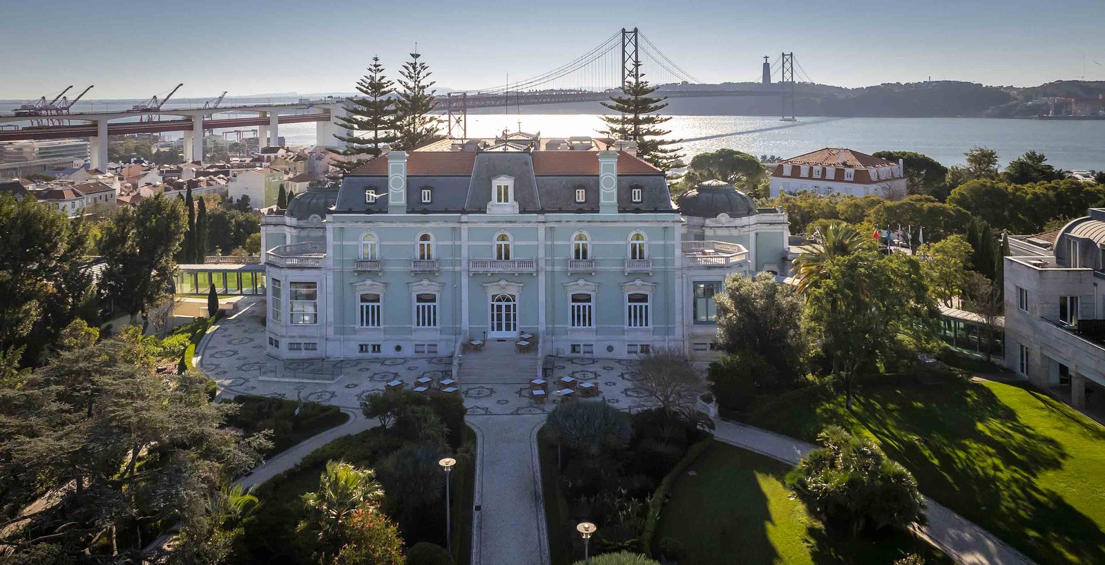The Valle Flôr palace seen from above among its gardens and pines, with the 25 de Abril Bridge and the Tagus behind, Pestana Palace, Lisbon The Valle Flôr palace seen from above among its gardens and pines, with the 25 de Abril Bridge and the Tagus behind, Pestana Palace, Lisbon