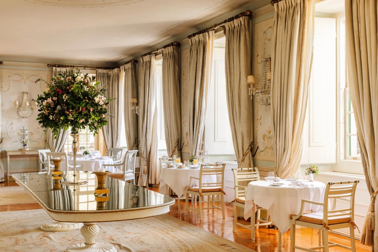 Gilded salon with painted walls, long curtains and laid tables at the Valverde Palácio de Seteais, Sintra