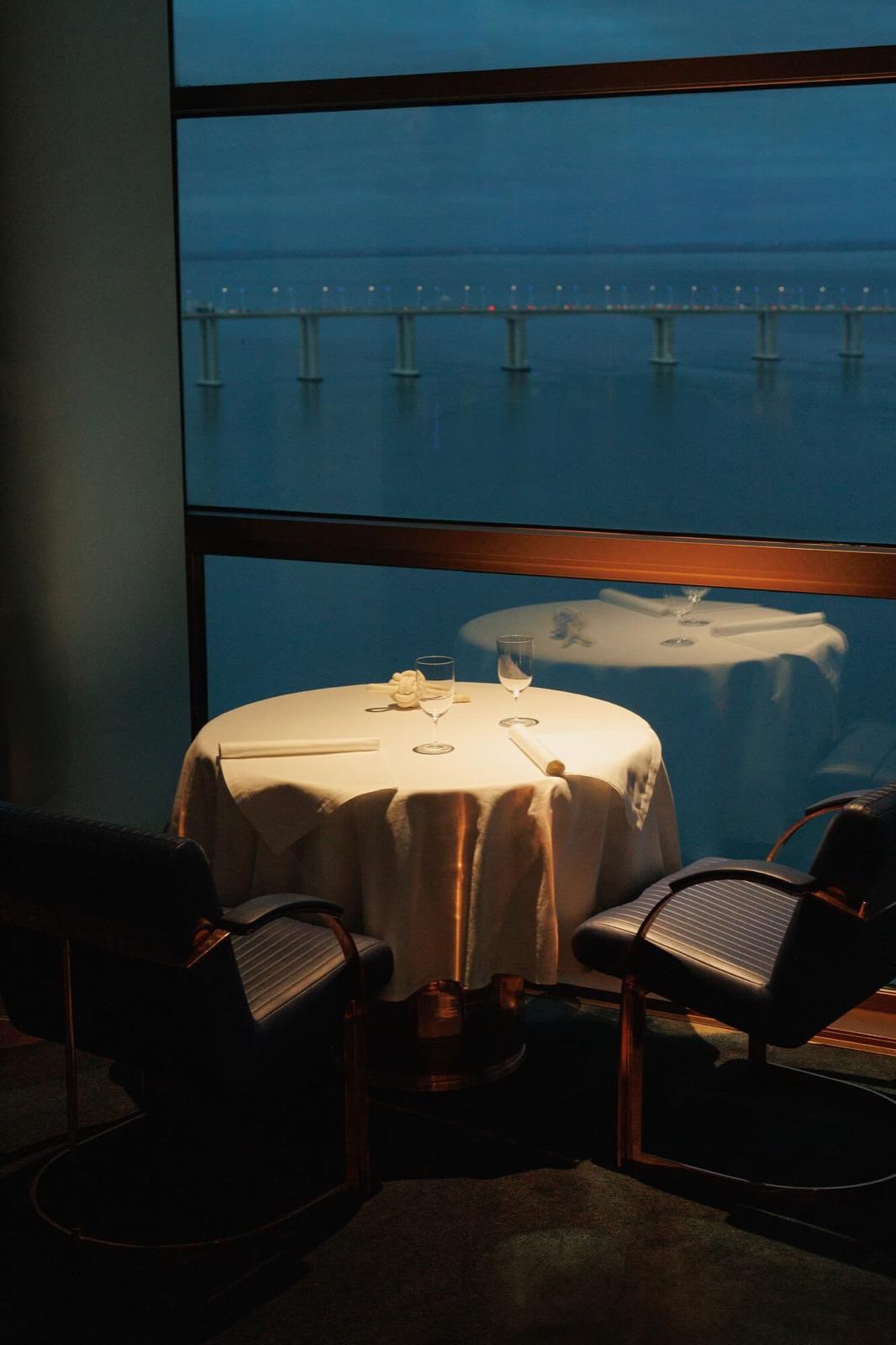 A table for two by the window at night, high above the river, at Fifty Seconds, Lisbon