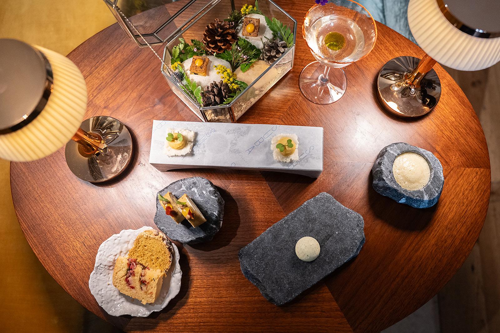 Table seen from above with small plates, glasses and warm table lamps at Suba, Palácio Santa Catarina, Lisbon