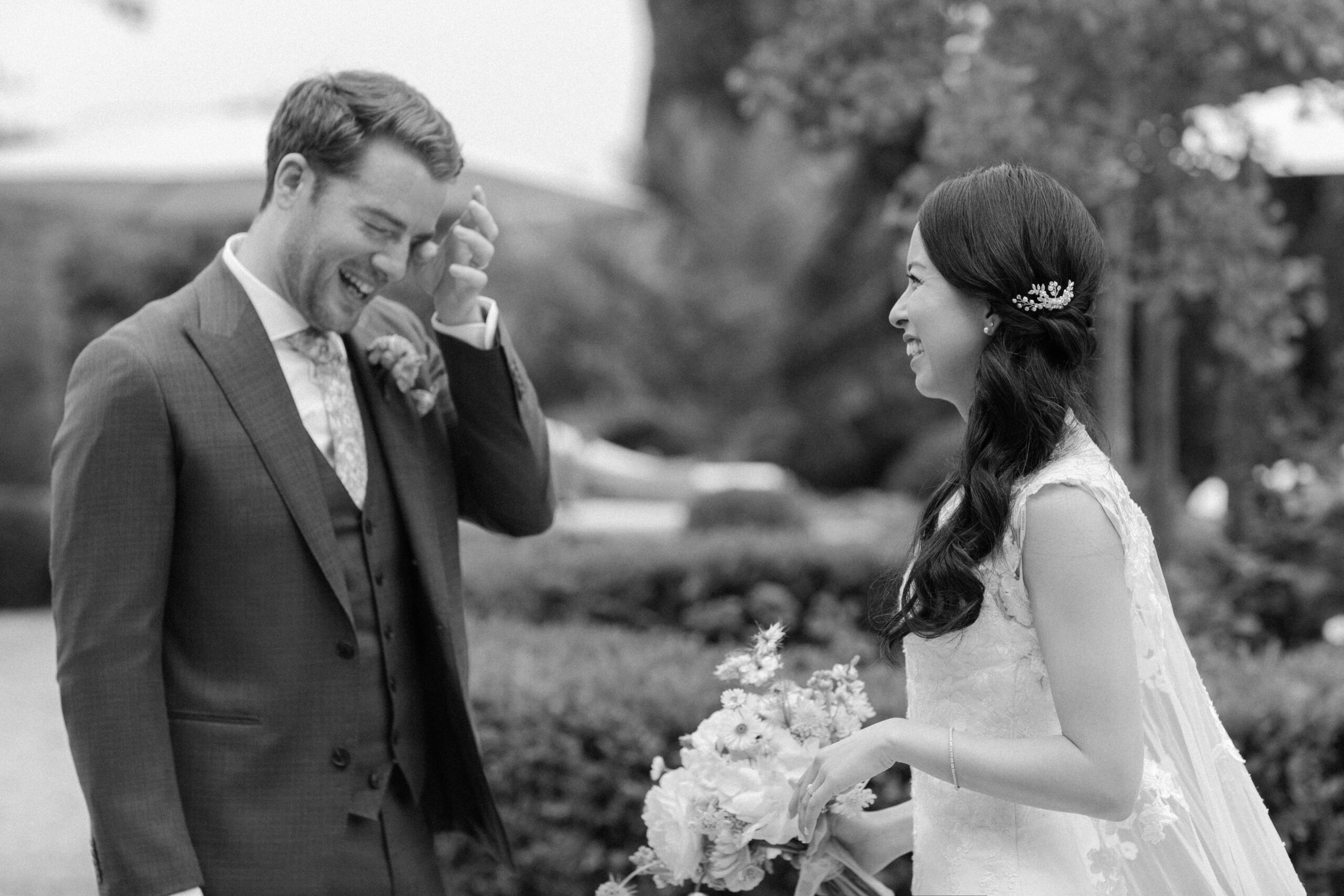 Emotional groom wiping a tear during a classic First Look with his bride at their wedding.