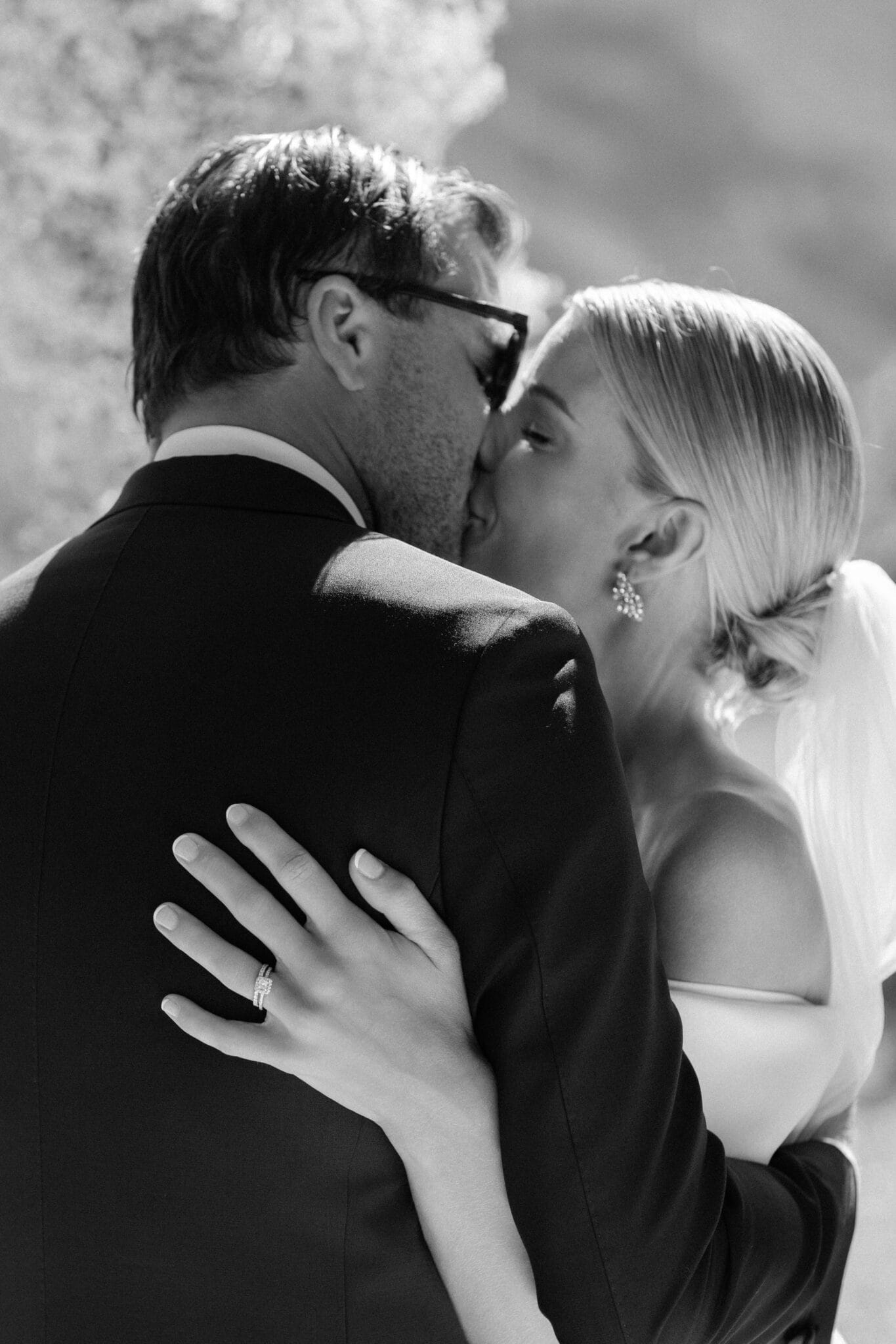 Intimate black and white close-up of bride and groom kissing, with focus on her engagement ring, during their Lake Como wedding