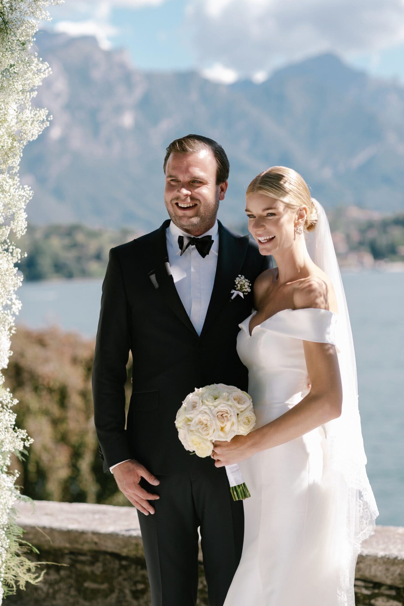 Bride holding bouquet and groom smiling together during their wedding at Villa Carlotta.