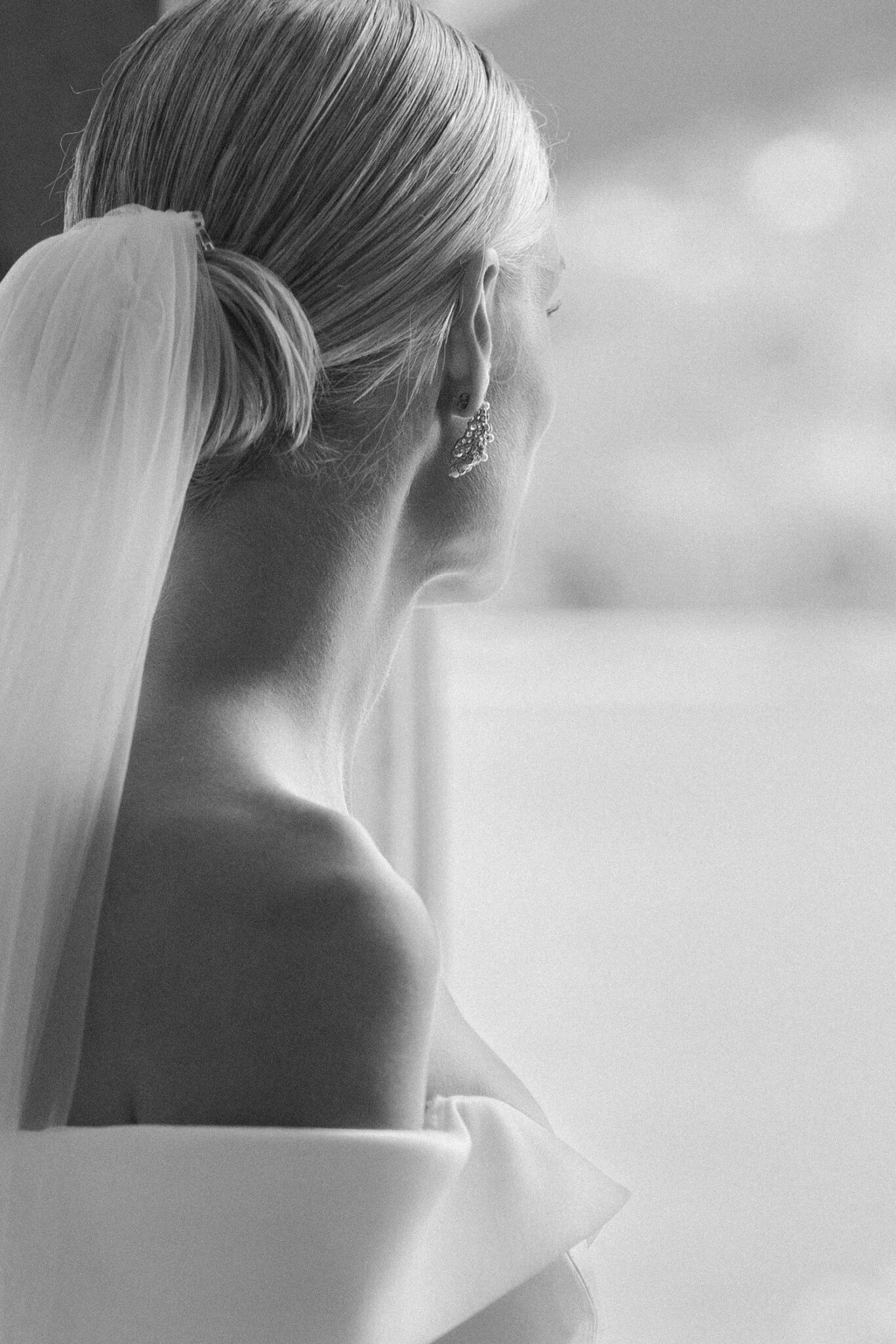 Elegant black and white bridal profile with veil and earring at Villa Carlotta.