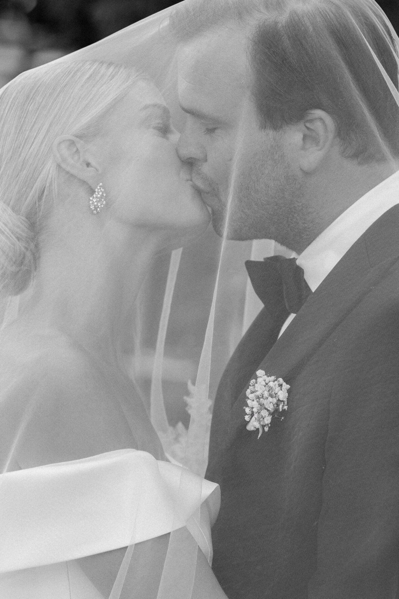 Bride and groom sharing a kiss under the veil during their Villa Carlotta wedding.