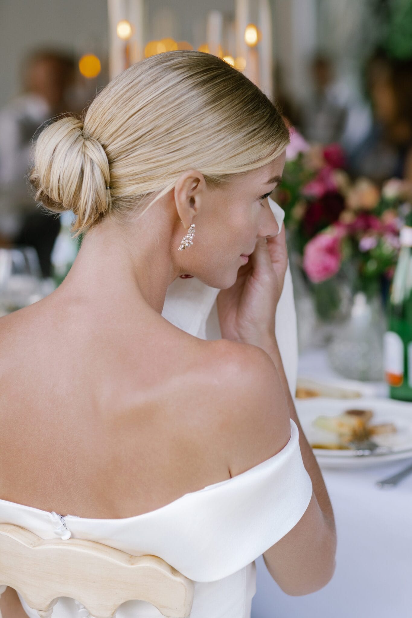 Bride seated at the dinner table with sleek bun and elegant gown at Villa Carlotta.