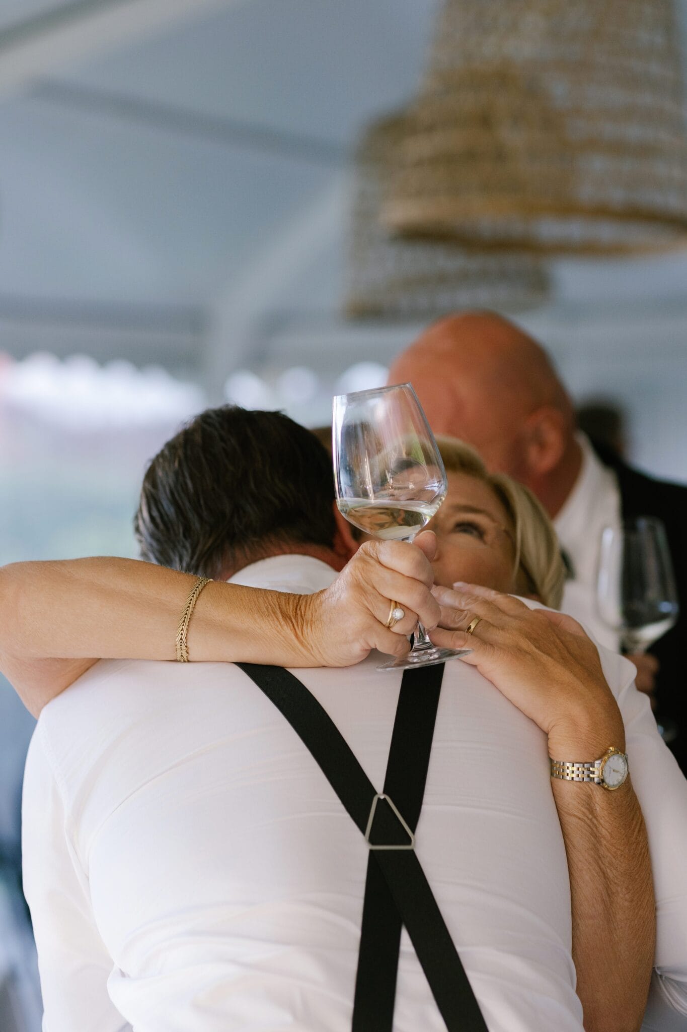 Wedding guest warmly hugging groom during Lido di Lenno reception.