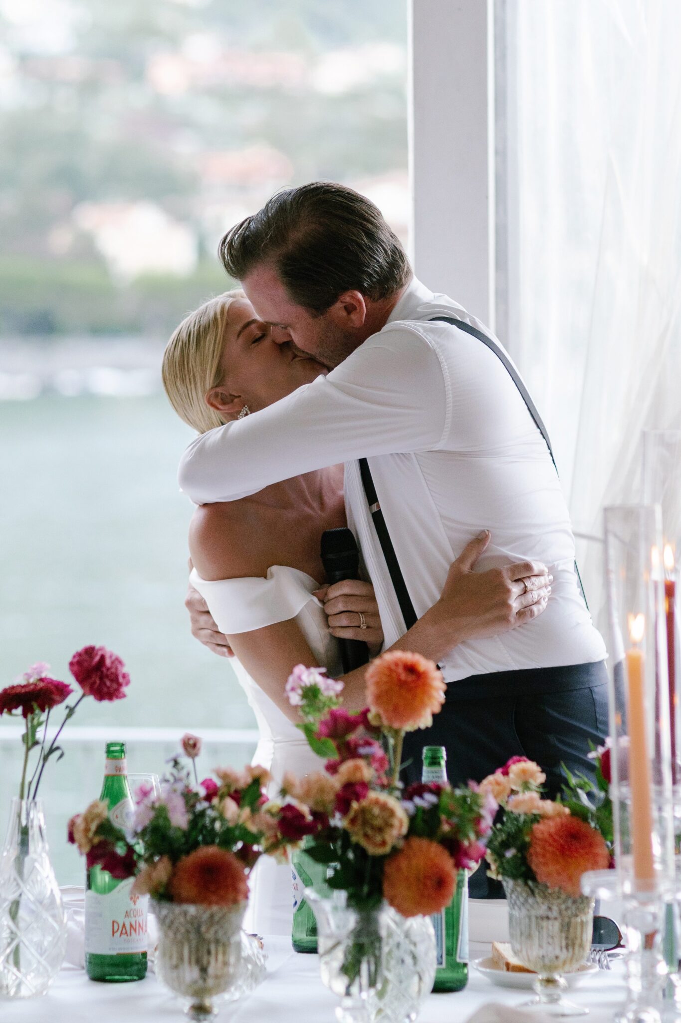 Bride and groom kissing by a window during their wedding reception at Villa Carlotta.