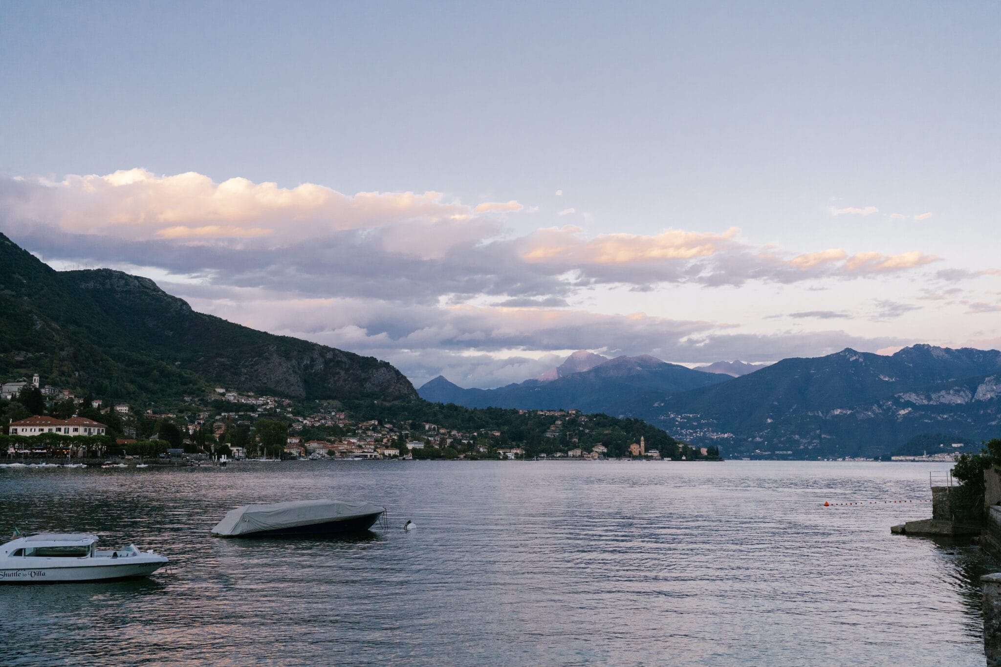 Scenic view of Lake Como at sunset with boats on the water.