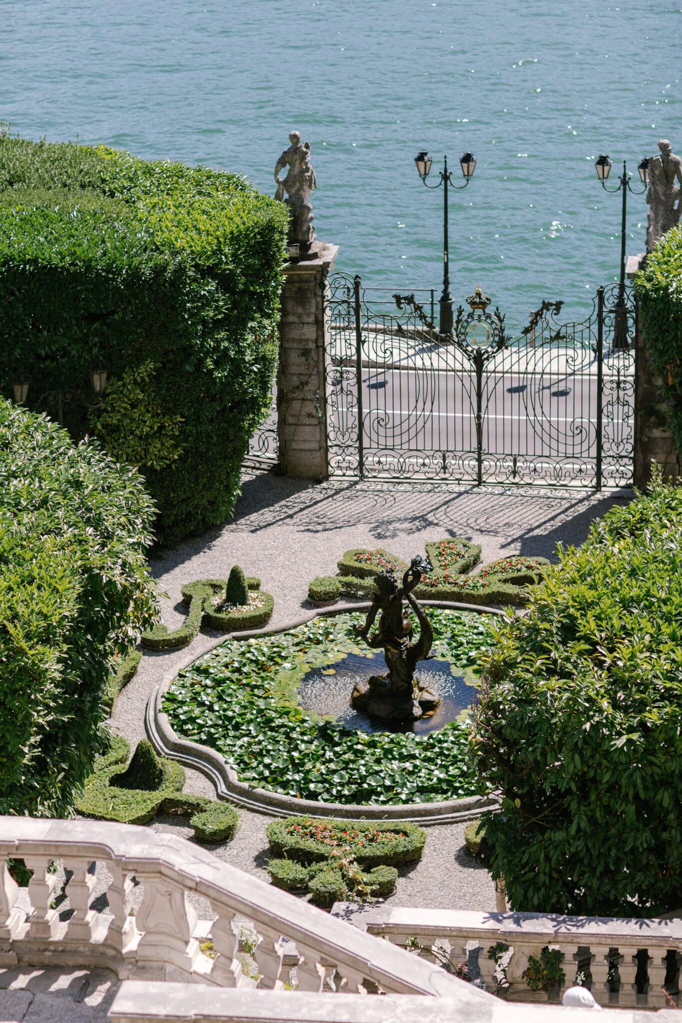 Garden fountain and ornate lakeside gate at Villa Carlotta overlooking Lake Como.