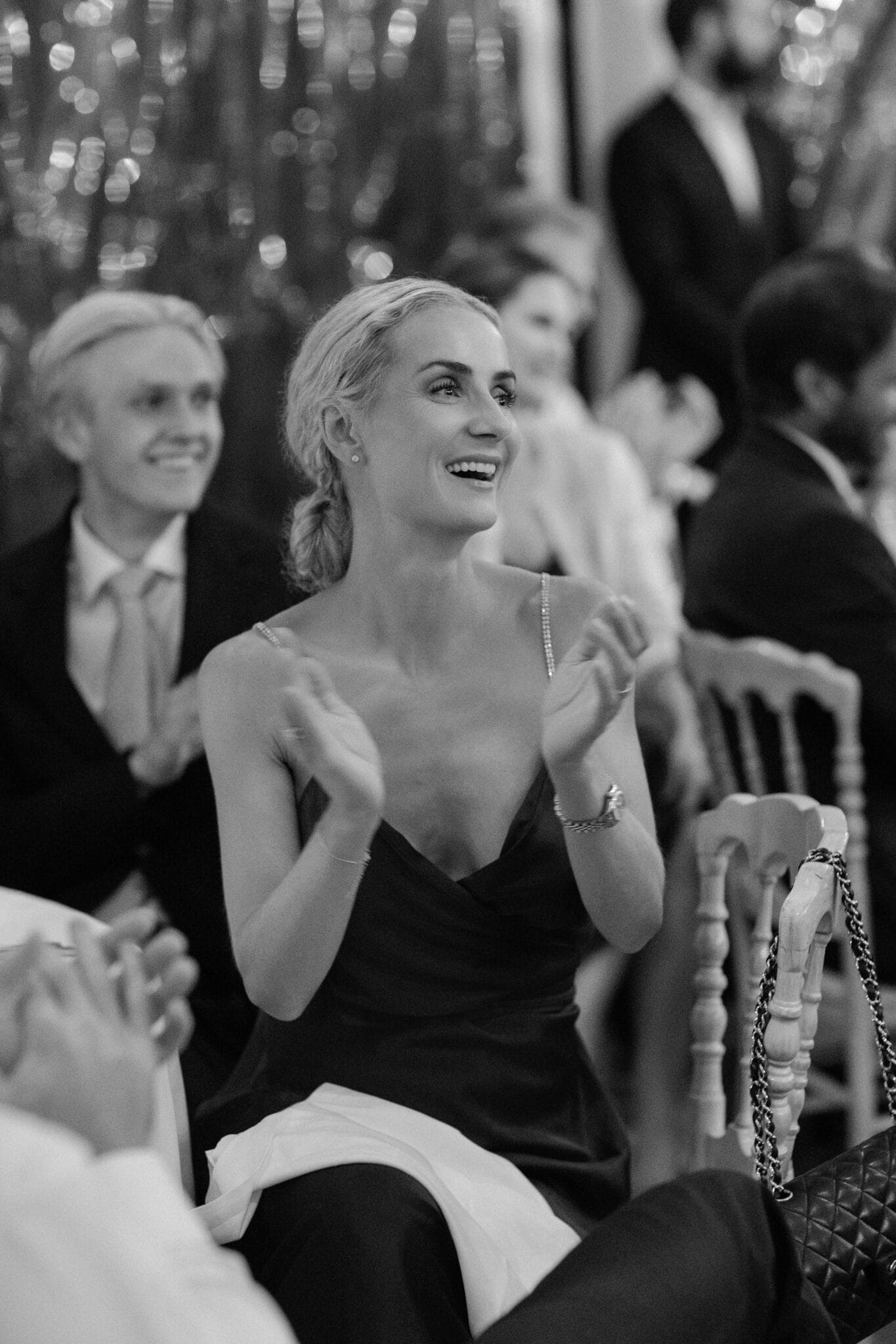 Wedding guest smiling and clapping during reception speeches at Lido di Lenno.