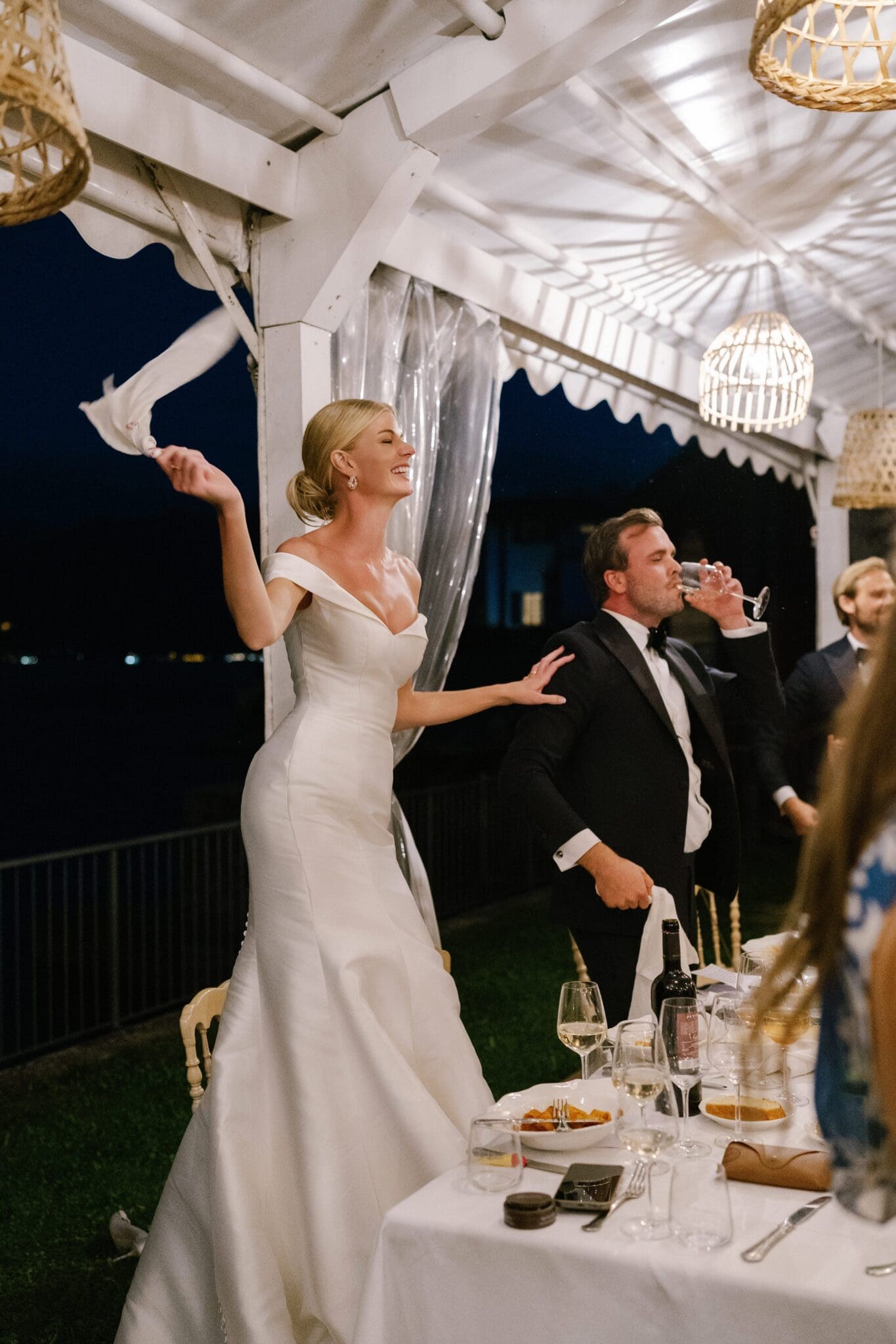 Bride standing on the dinner table during wedding reception at Lido di Lenno.