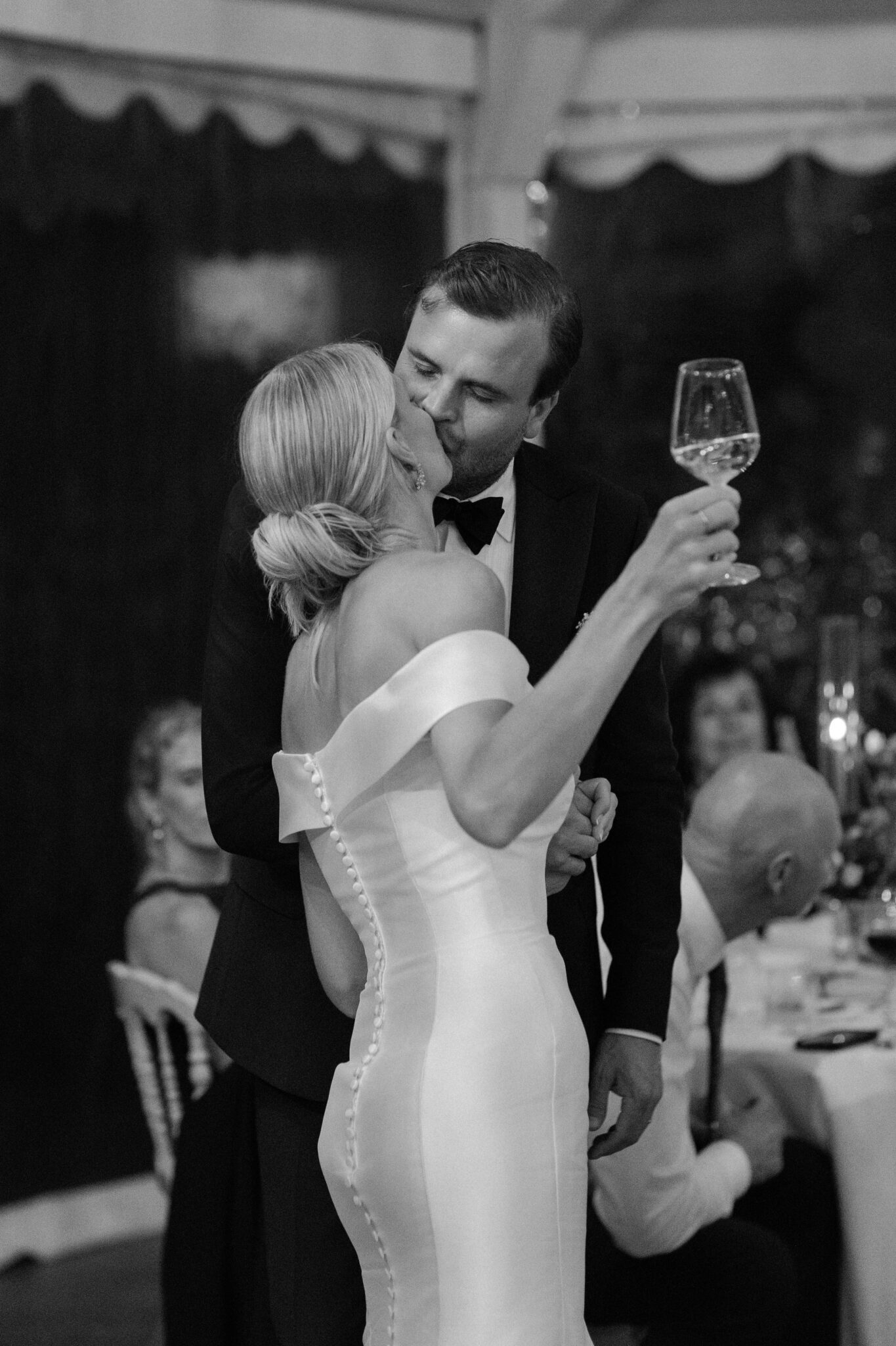 Bride and groom sharing a toast and kiss during their Villa Carlotta wedding dinner.
