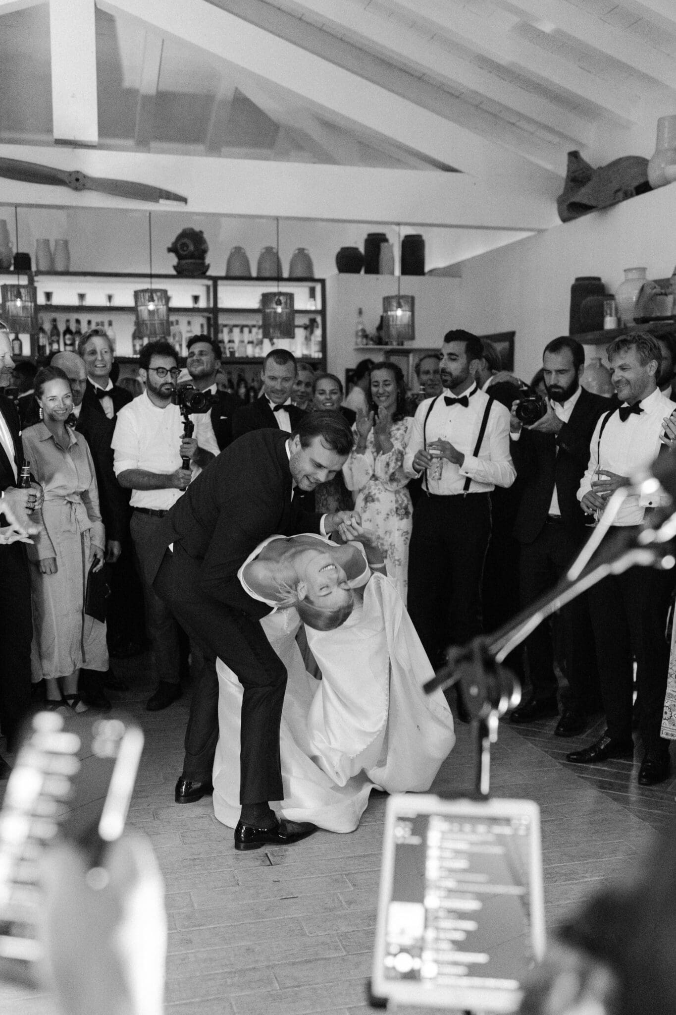 Bride and groom dancing joyfully during their wedding reception surrounded by guests at Lido di Lenno.
