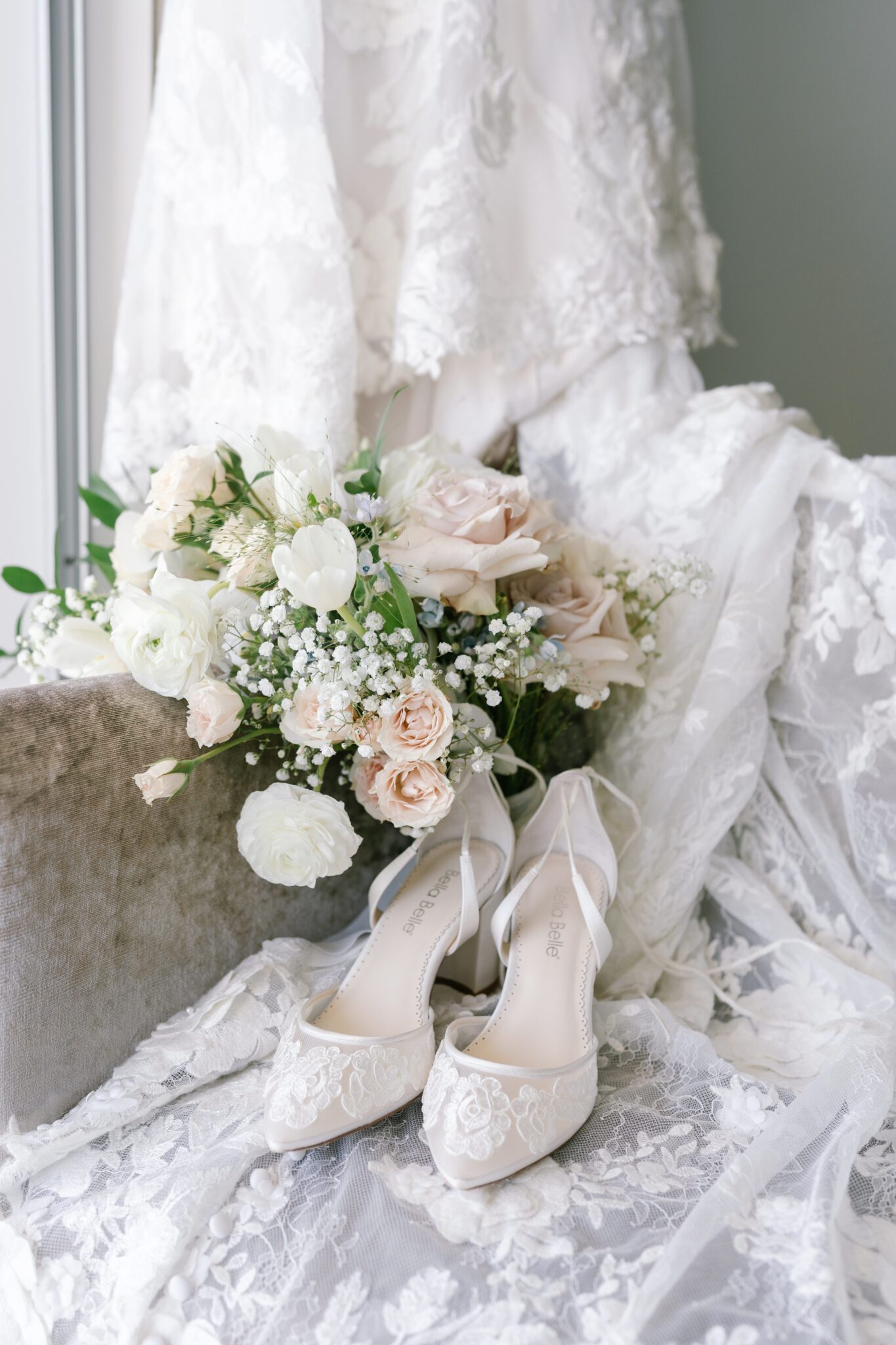 Elegant bridal bouquet with pastel roses and lace heels placed on the bride’s gown in Portugal