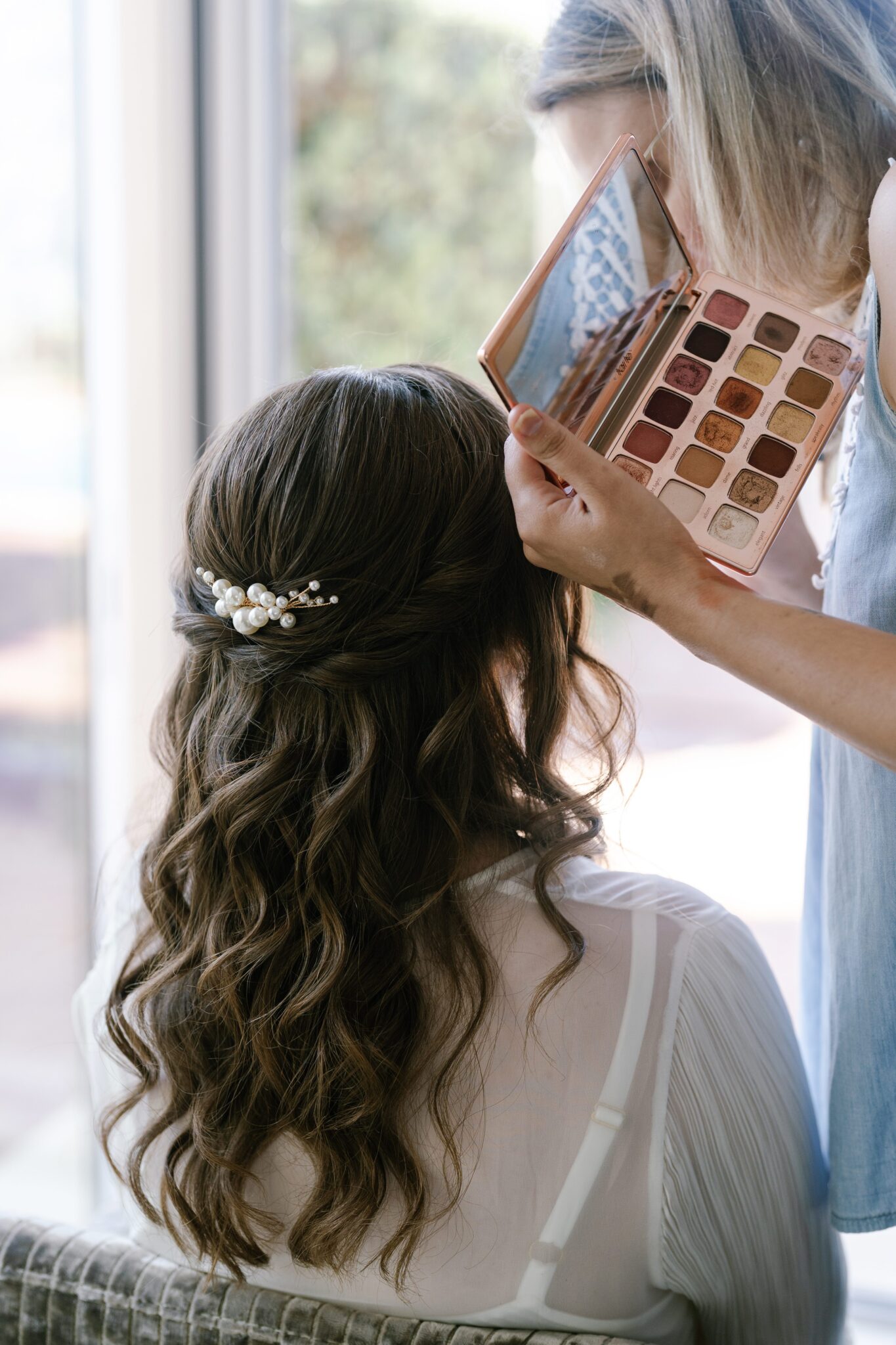 Bride getting her makeup done with warm tones palette during morning preparations in Portugal