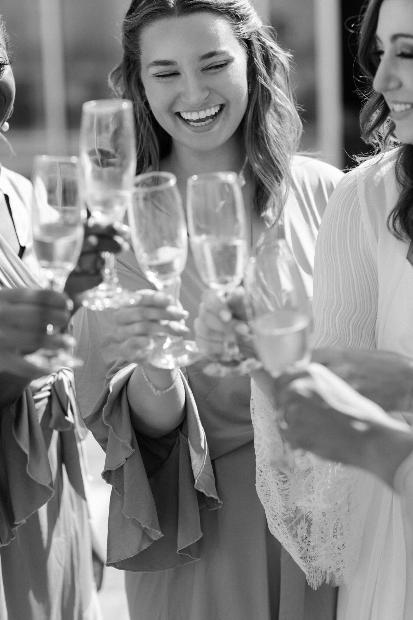 Bridesmaids toasting with champagne glasses during joyful morning in Portugal black and white photo