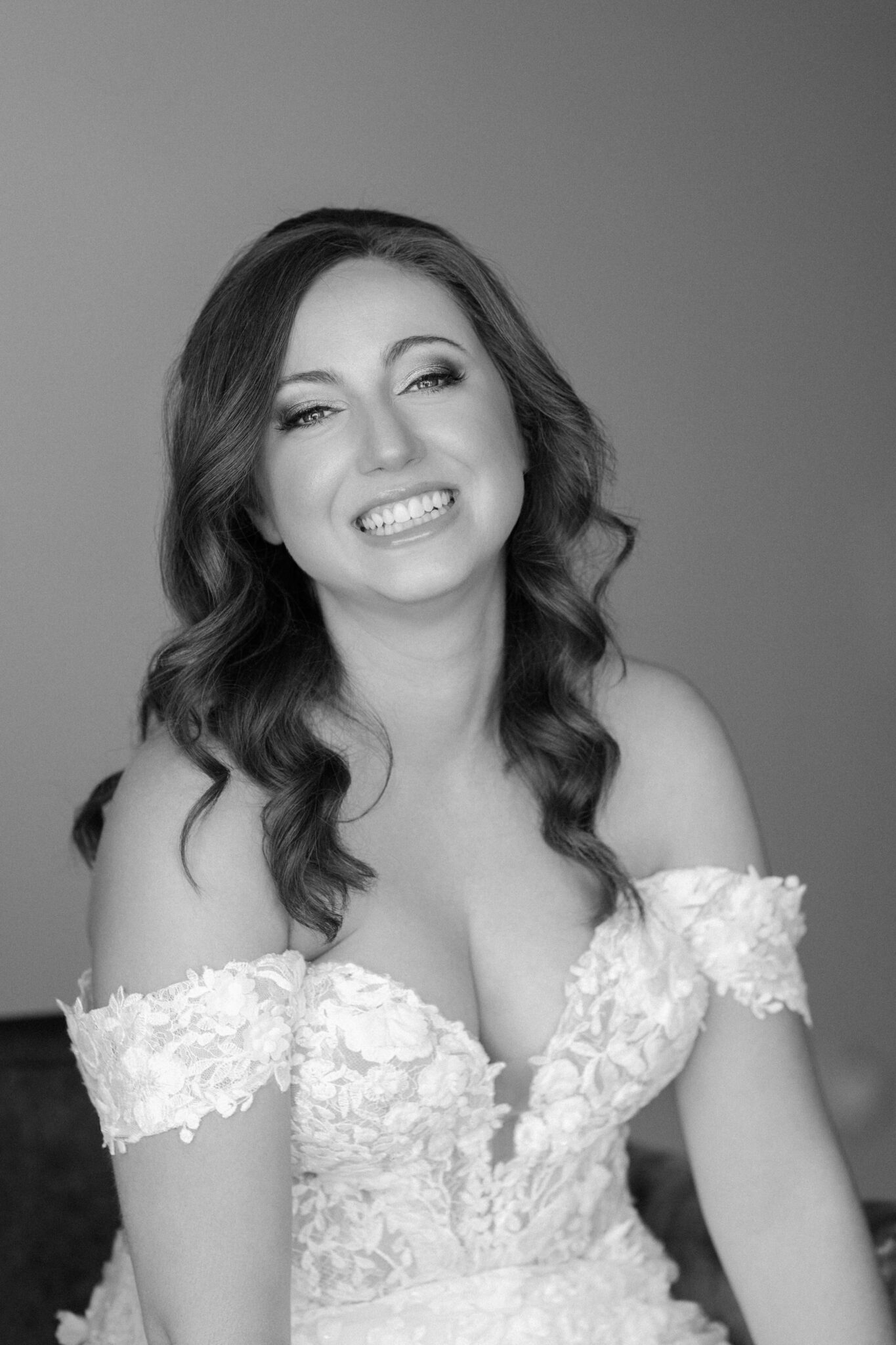 Black and white portrait of smiling bride in lace gown on her wedding day in Portugal