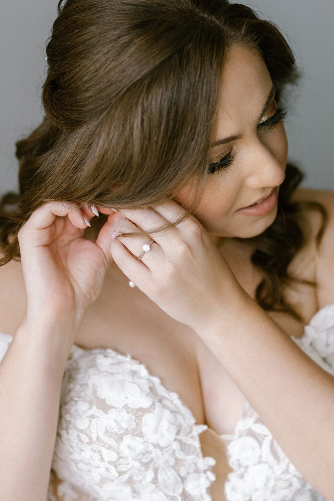 Bride adjusting her pearl earrings during morning preparations before the wedding in Portugal