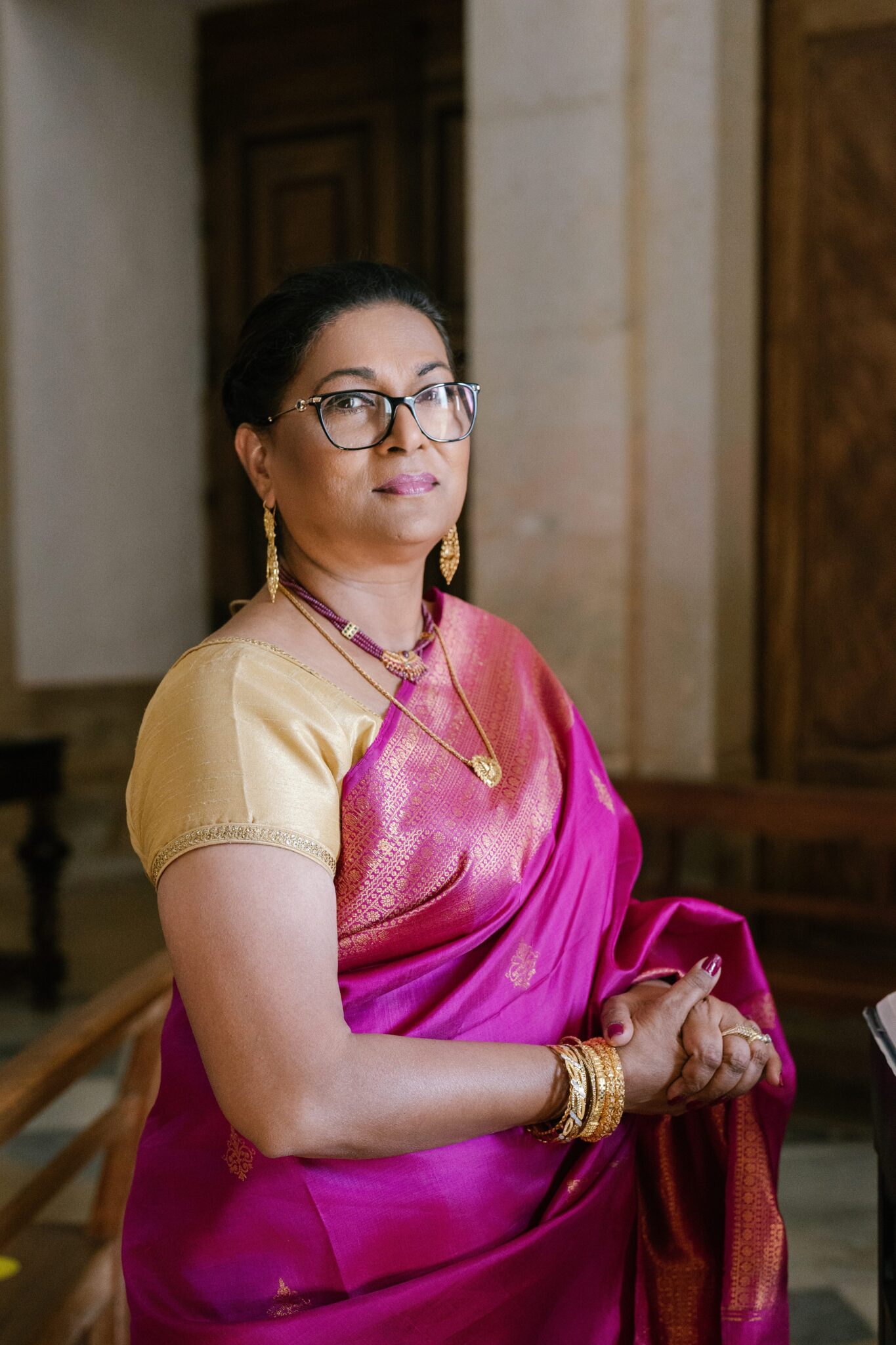 Mother of the groom in traditional pink and gold sari during Portugal wedding ceremony