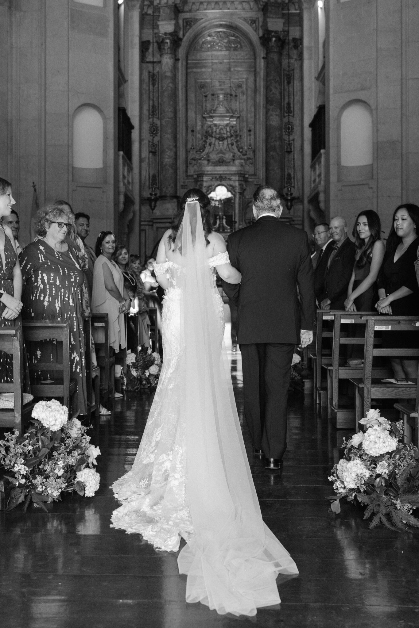 Bride walking down the aisle with her father inside church in Óbidos Portugal