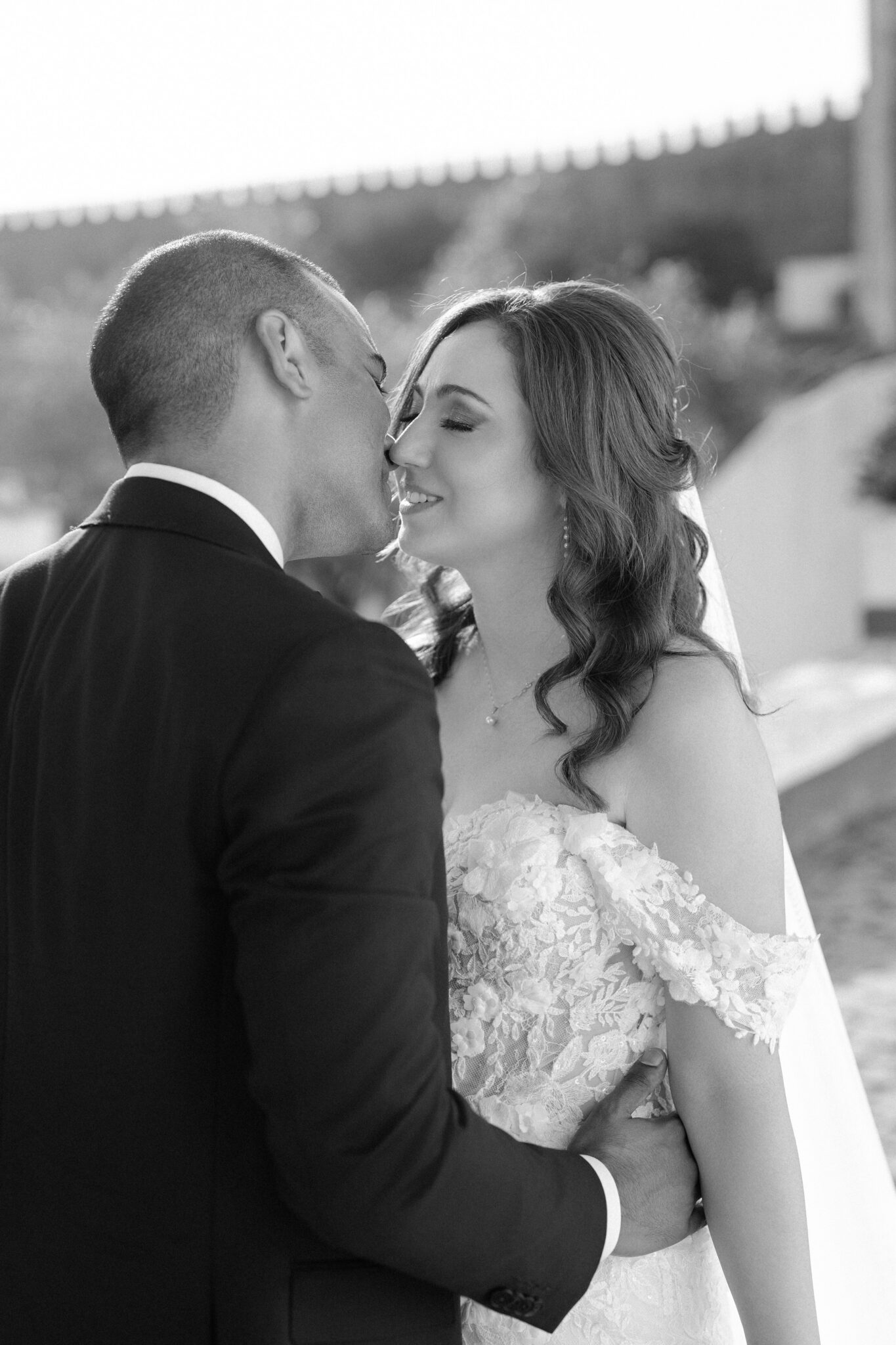 Bride and groom sharing a romantic kiss in black and white on their Portugal wedding day