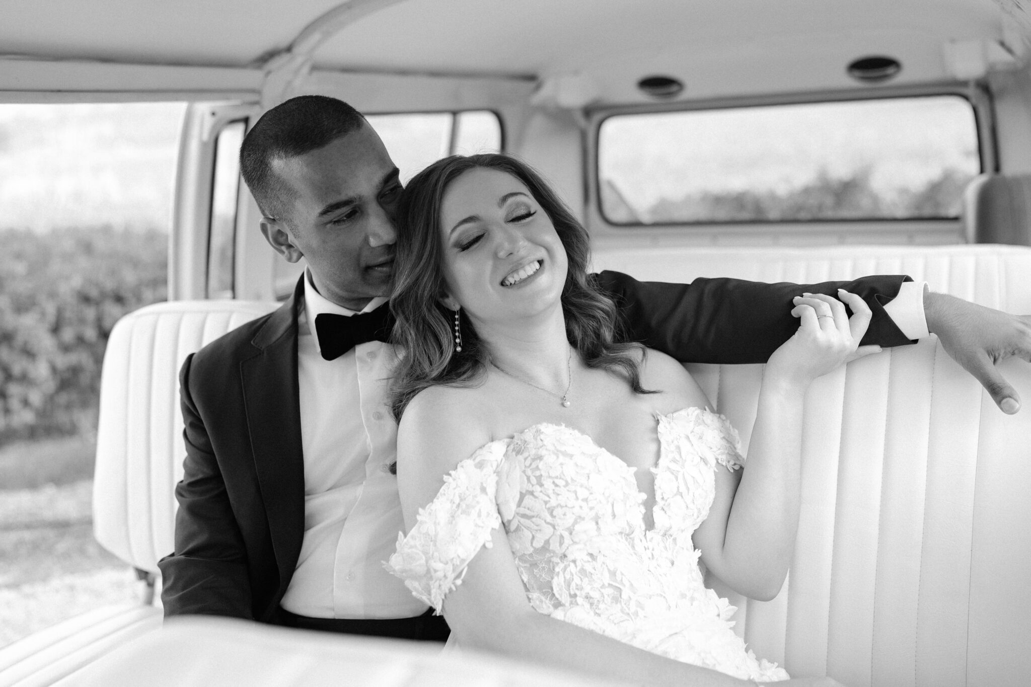 Groom looking lovingly at his smiling bride inside a vintage VW van in Portugal