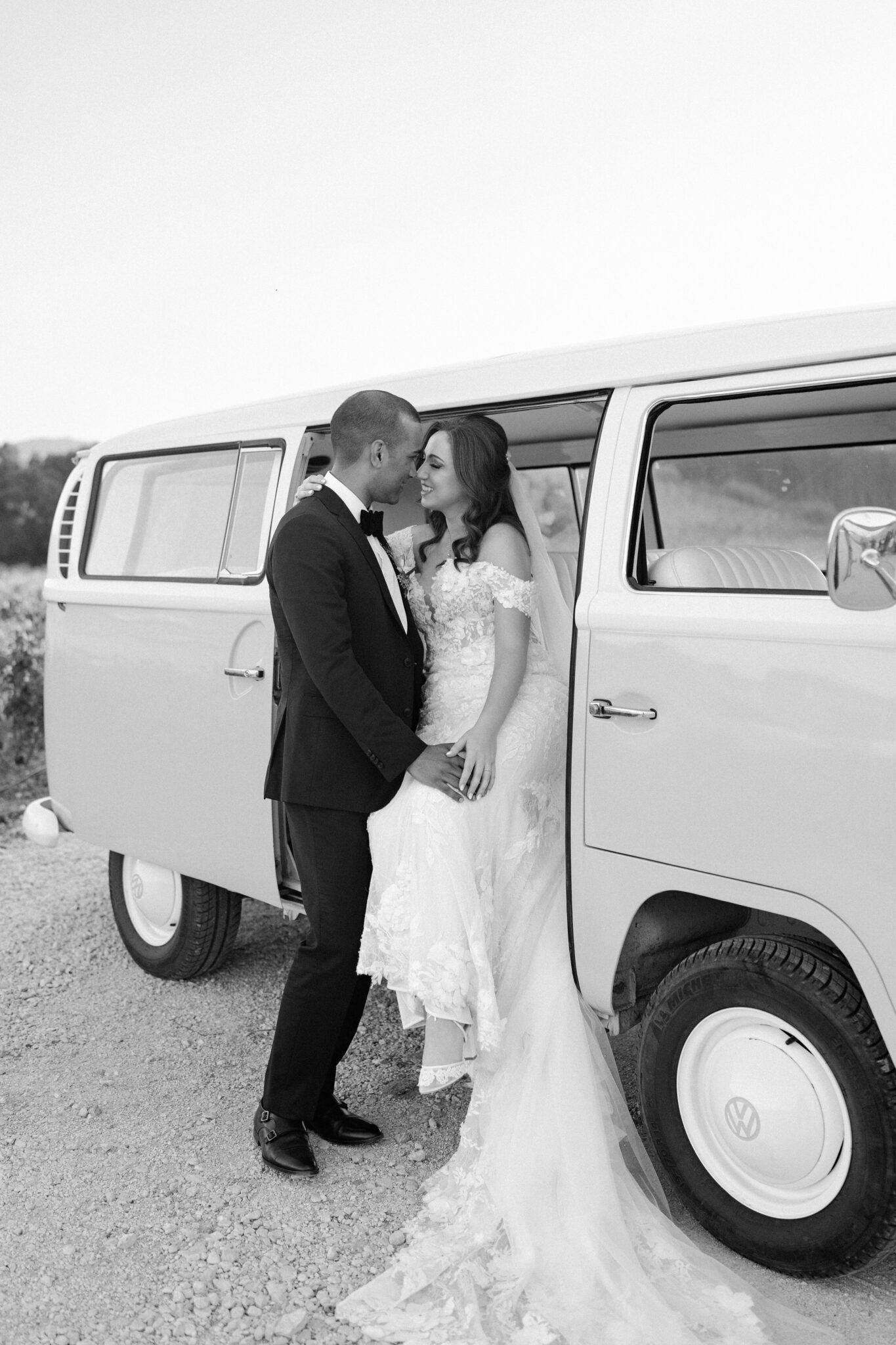 Bride and groom in tender embrace by vintage van in vineyard black and white wedding photo Portugal