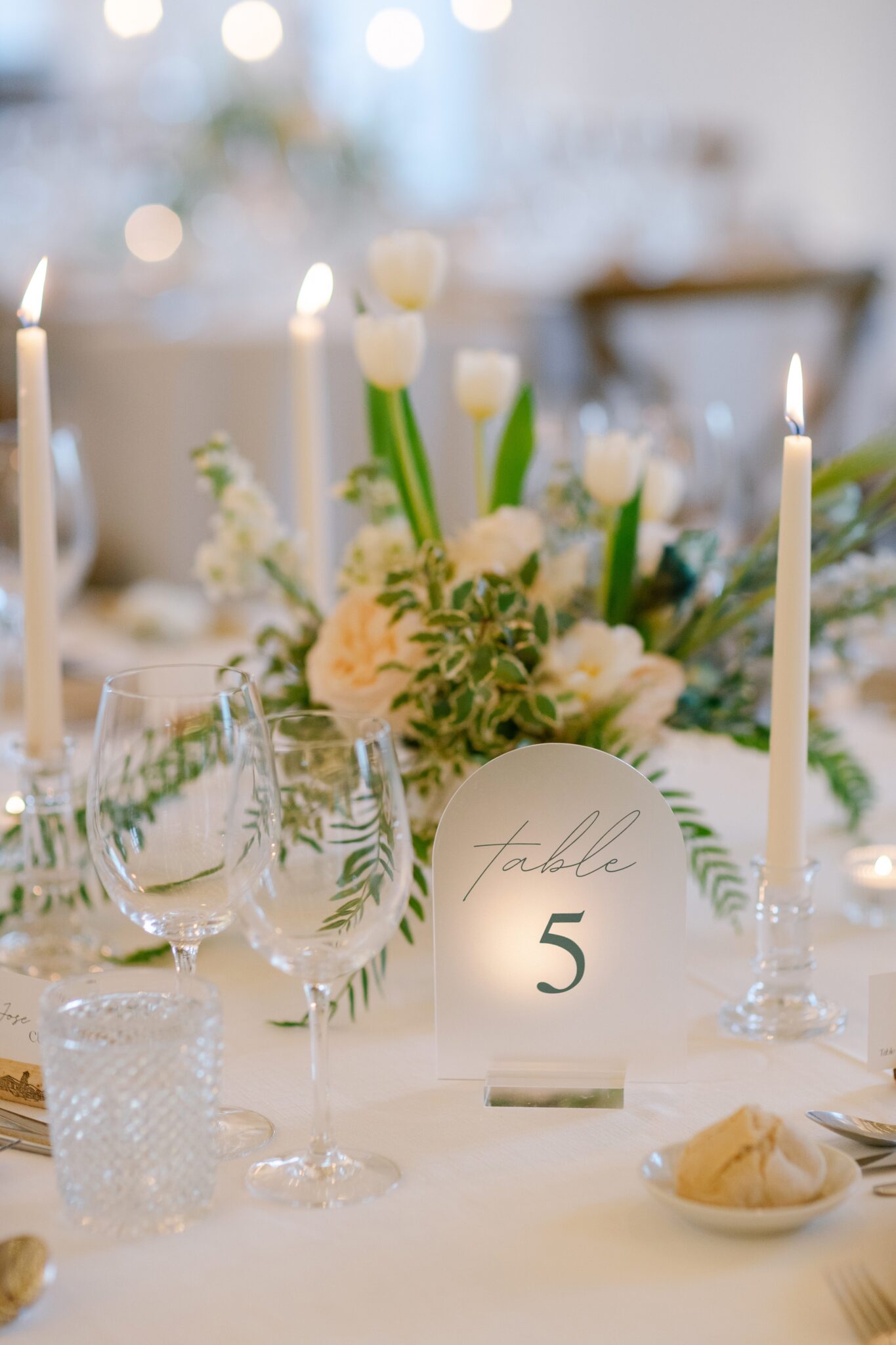 Wedding table centerpiece with flowers and table number five at Quinta do Gradil