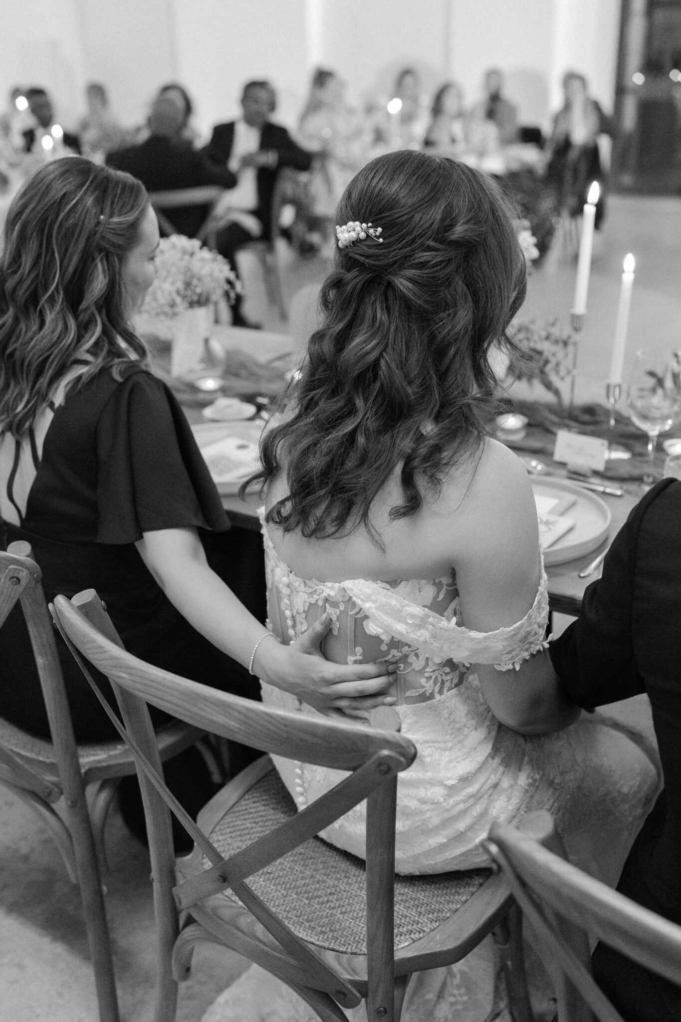 Bride in lace gown with pearl hairpiece seated at reception dinner at Quinta do Gradil