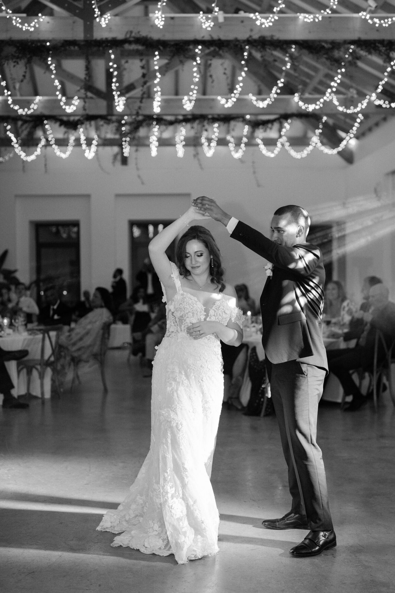 Bride and groom first dance under string lights at Quinta do Gradil in Portugal black and white wedding photo