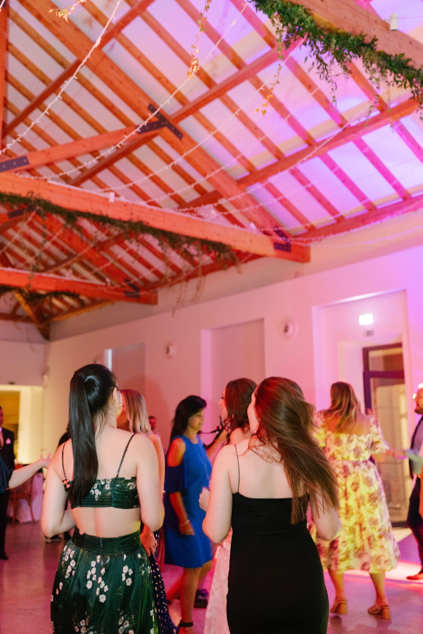 Wedding guests dancing under pink lights at Quinta do Gradil in Portugal reception party