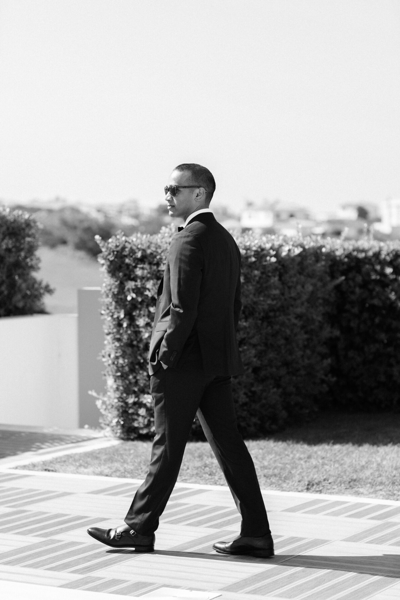 Groom walking outdoors in sunglasses before the wedding ceremony in Portugal